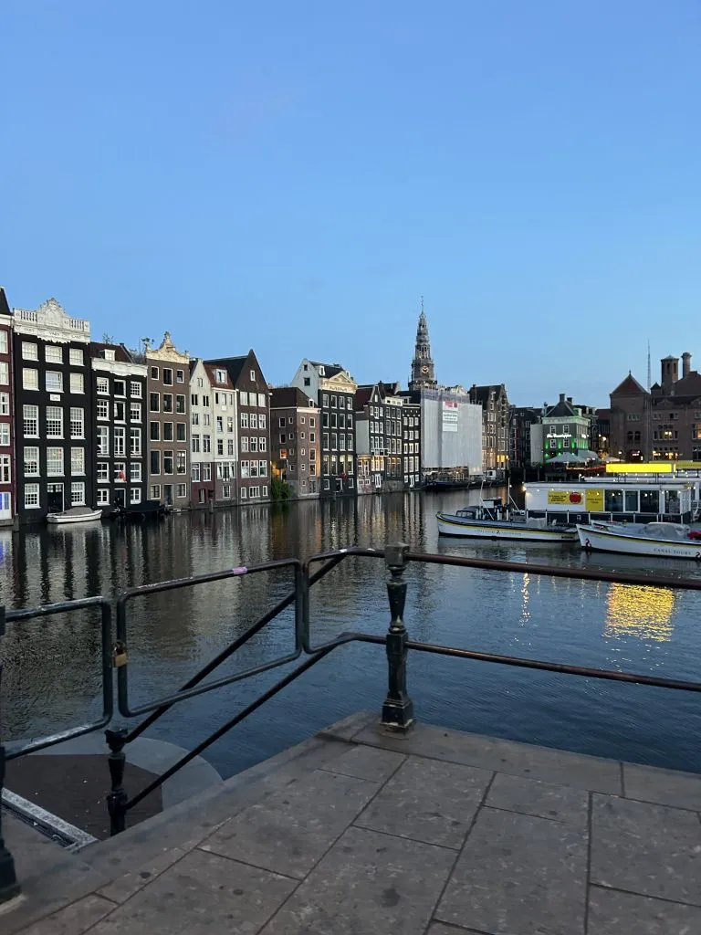 Narrow canal houses reflected in still water at sunset.