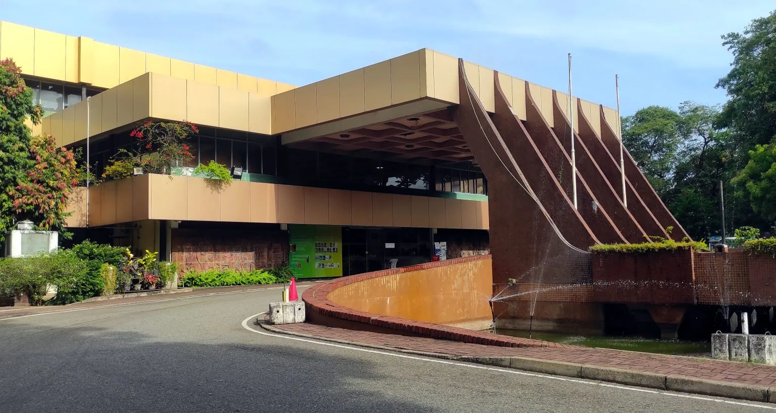 A modern beige public library building with rows of large windows.